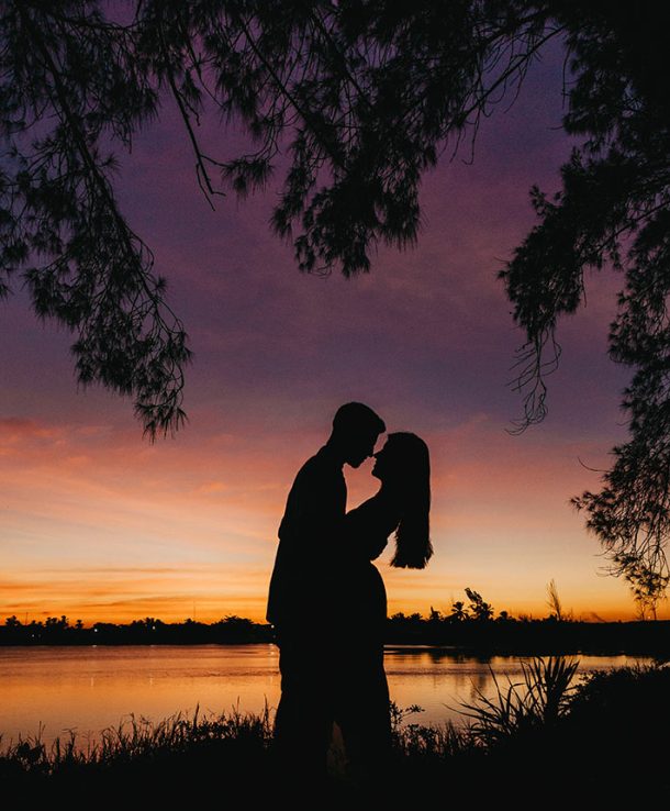 A vertical picture of beautiful silhouettes of lovers against a mesmerizing sky